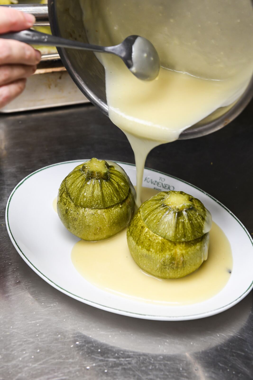 Chef σερβίρει σάλτσα σε κολοκυθάκια